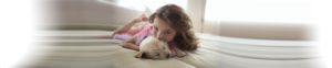 girl with dog on bed