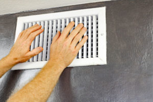 hands in front of hvac air vents