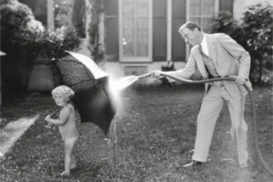 image of a dad hosing off a girl for cooling