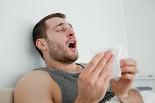 man about to sneeze indoors due to poor indoor air quality