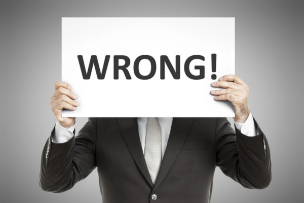 man holding a sign in front of his face that says wrong depicting Incorrectly Sized Ductwork