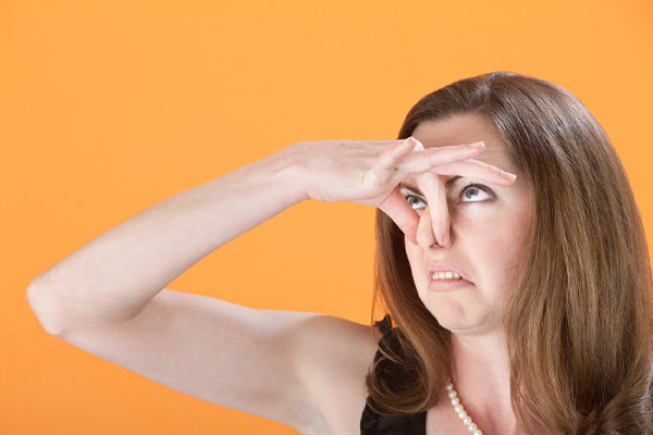 woman plugging nose due to smelly air conditioner