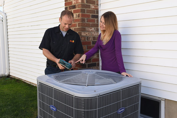 hvac contractor in hardhat discussing heating and ac installation plans with homeowner