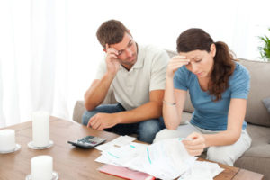 couple looking at energy costs and high cost of air conditioning
