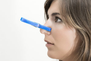 women plugging nose due to smelly air conditioner