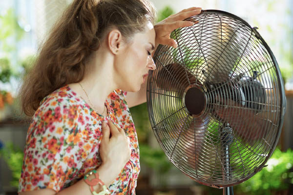 image of homeowner feeling hot and sticky due to high humidity levels indoors