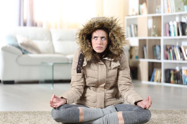 image of a homeowner feeling chilly due to running out of heating oil during winter