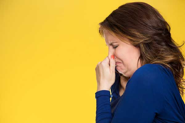 image of a homeowner plugging nose due to furnace odor and overheating