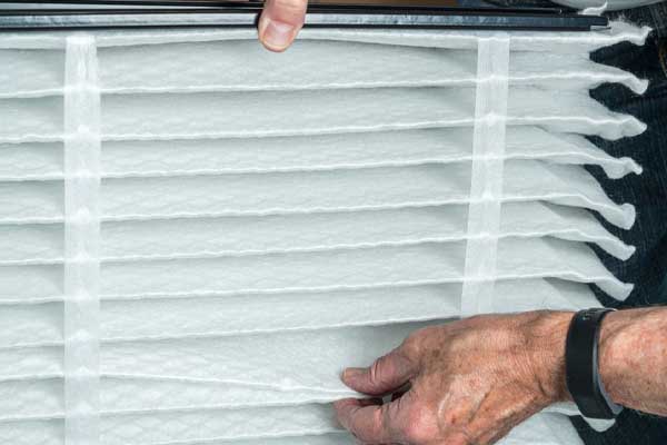 image of a senior man replacing his furnace filter