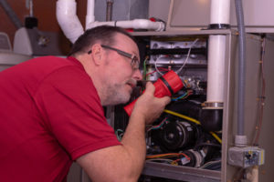 image of an hvac contractor servicing furnace heating system