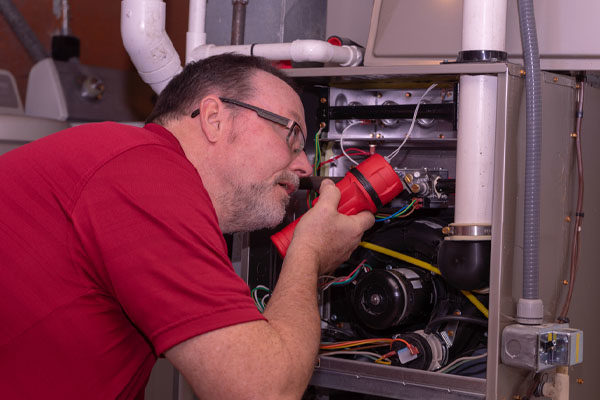 image of an hvac contractor repairing an old outdated furnace