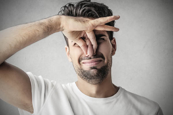 image of a homeowner plugging nose due foul odors at home