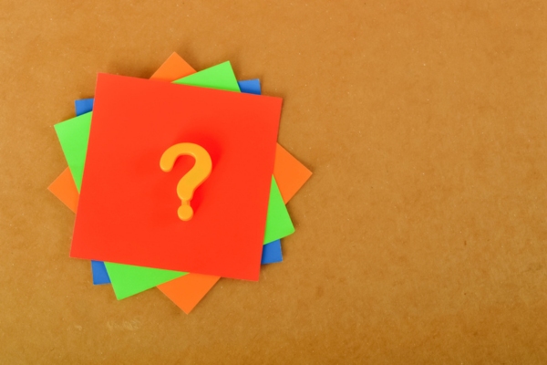 question mark on a stack of colored papers depicting FAQS about Air Conditioner Tune-Up
