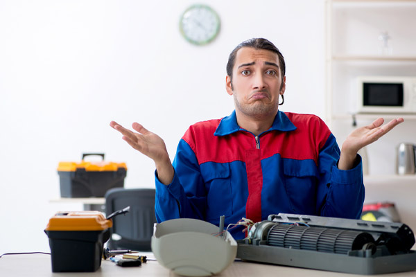 image of confused hvac contractor performing air conditioner repair