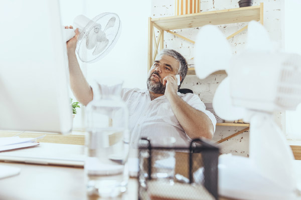 image of homeowner feeling hot due to air conditioner malfunction