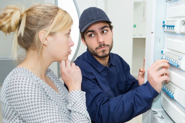 HVAC contractor with customer analyzing problem in circuit breaker and air conditioner