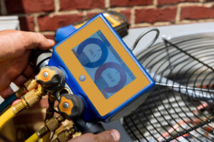 image of hvac contractor measuring refrigerant in an air conditioner and overcharged ac systmptoms