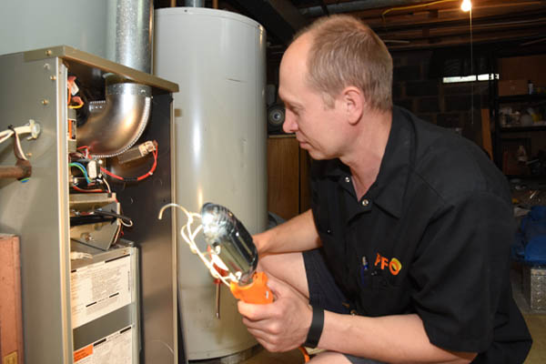 image of an hvac contractor performing furnace maintenance service