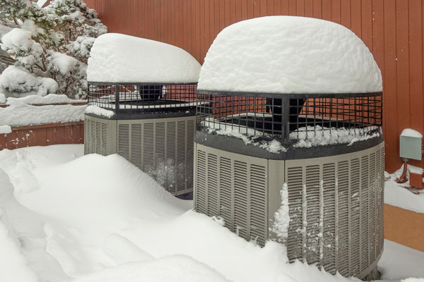 heat pump in snow depicting auxiliary heat vs emergency heat