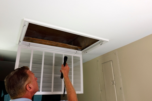 Homeowner inspecting HVAC ducts