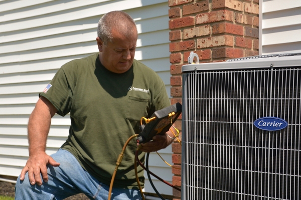 PFO Heating & Air Conditioner Technician maintaining outdoor HVAC unit