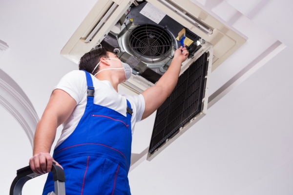 Professional HVAC Technician cleaning indoor unit