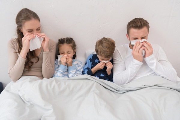 family in bed blowing noses due to dirty HVAC air filter