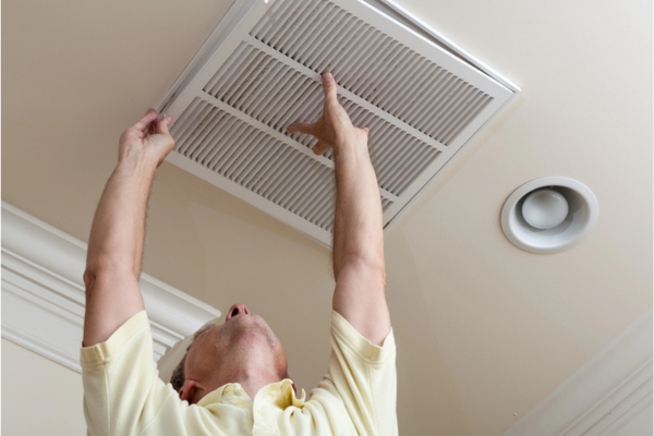 homeowner replacing HVAC air filter