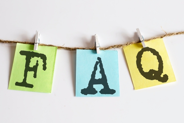 FAQ stamped on colored paper clipped on a thin rope depicting questions about heat pump blowing hot air in cool mode