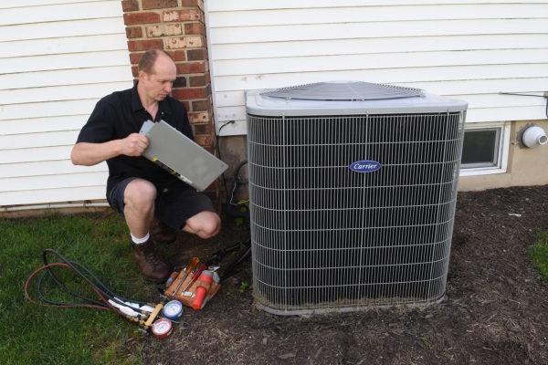 PFO Heating & Air Conditioning HVAC technician checking heat pump's electrical and wiring