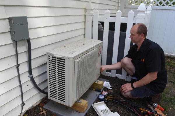 PFO Heating & Air Conditioning HVAC technician diagnosing a heat pump