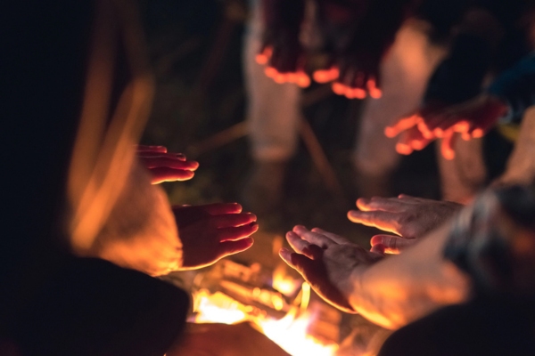 people warming hands on a campfire