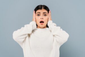 brunette woman covering ears depicting furnace noise