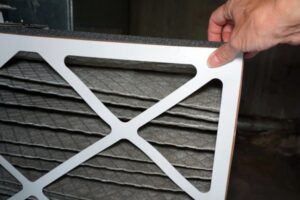 homeowner removing dirty HVAC filter