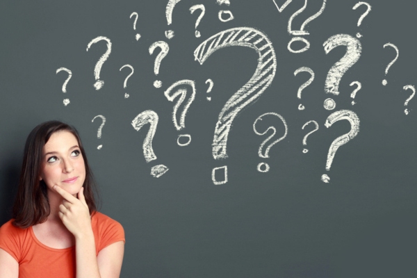 woman looking up on question mark doodles on a chalkboard depicting HVAC Allergies FAQs