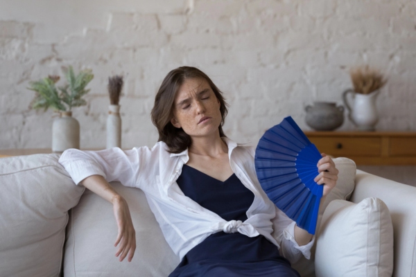 Exhausted overheated girl feeling hot at home due to summer heat and power outage