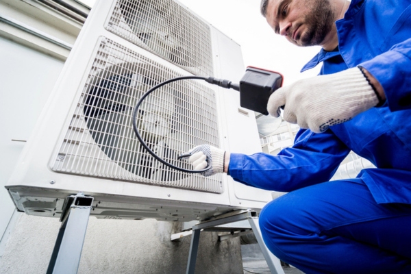HVAC technician tending to outdoor AC unit