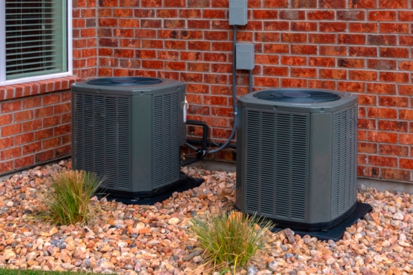 air conditioner units against a red brick wall