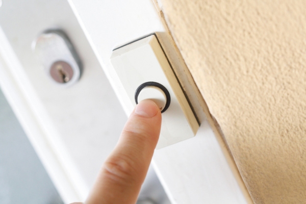 man's hand ringing the doorbell depicting unsolicited sales visit