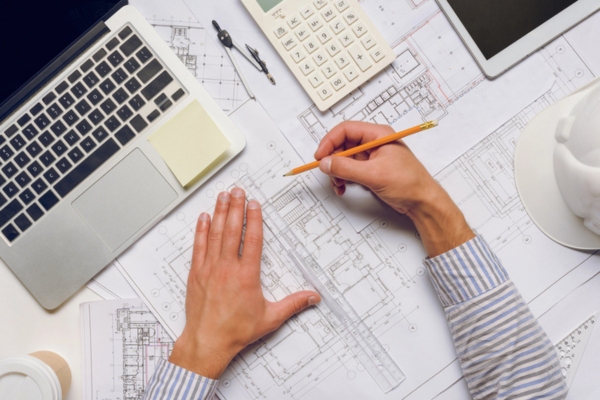 architect working on blueprints for a building design