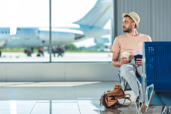 man waiting and keeping cool at the airport with air conditioner