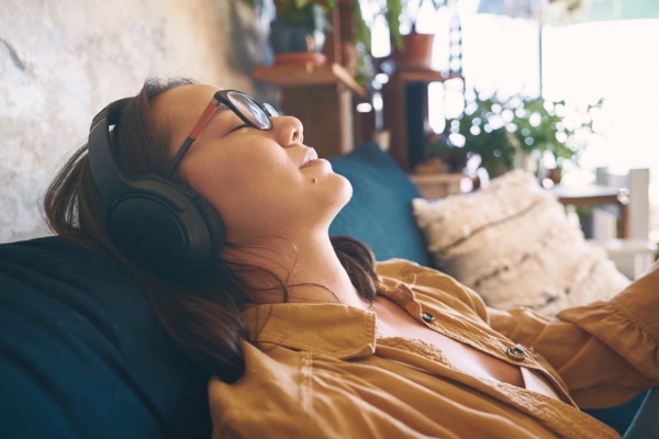 woman using headphones while keeping cool in a public place