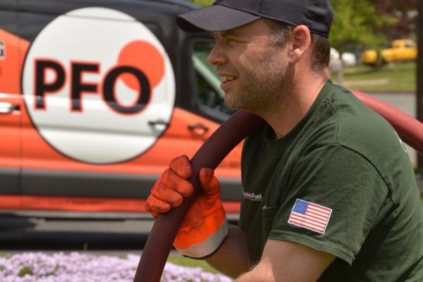 PFO Heating & Air Conditioning Oil delivery service driver carrying hose